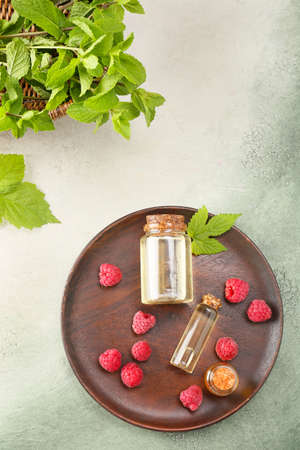Bottles of raspberry essential oil on color backgroundの写真素材