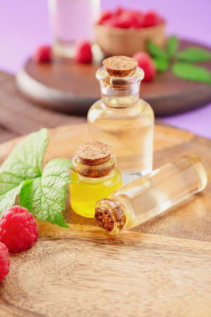 Bottles of raspberry essential oil on tableの写真素材