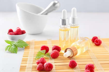 Bottles of raspberry essential oil on tableの写真素材