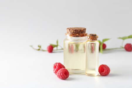 Bottles of raspberry essential oil on light backgroundの写真素材