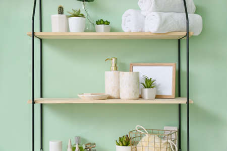 Shelf with bath accessories on color wallの写真素材