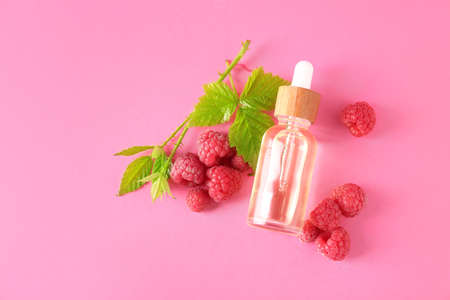 Bottle of raspberry essential oil on color backgroundの写真素材