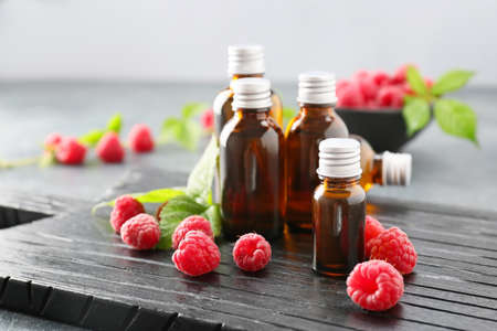 Bottles of raspberry essential oil on tableの写真素材