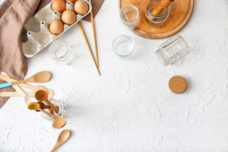 Jars with wooden cutlery and eggs on white background. Ecology concept