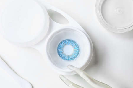 Container with contact lenses and tweezers on white backgroundの写真素材