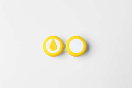 Container with contact lenses on white background