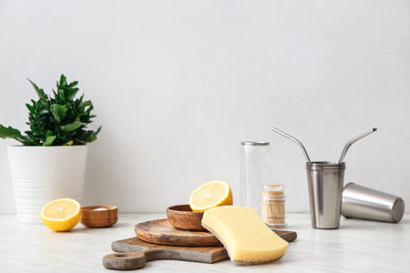 Wooden utensils with sponge and lemon on table in kitchen. Ecology conceptの写真素材