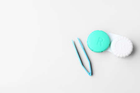 Container with contact lenses and tweezers on white backgroundの写真素材