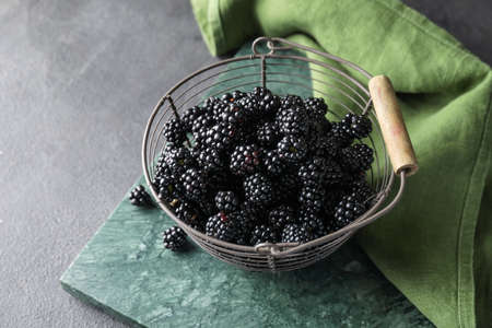 Basket with tasty blackberry on dark backgroundの写真素材