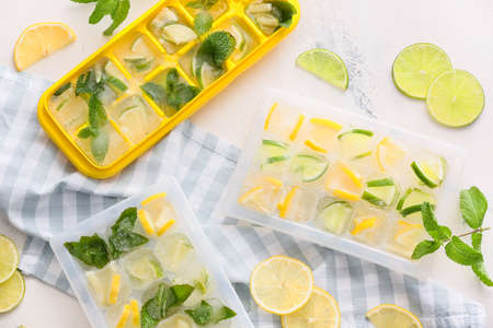 Trays with citrus fruits in ice on white backgroundの写真素材