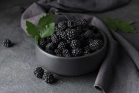 Bowl with tasty blackberry on dark backgroundの写真素材