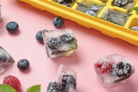Ice with frozen berries on color backgroundの写真素材