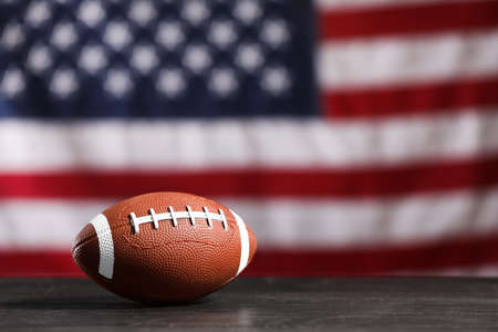Rugby ball on table against national flag of USAの写真素材