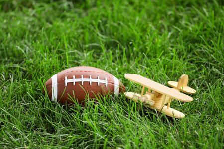 Rugby ball with wooden airplane outdoors
