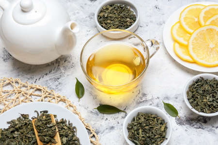 Cup of hot aromatic tea with dry tea leaves on tableの写真素材