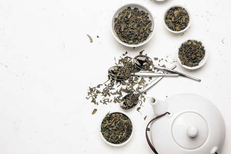 Bowls and spoons with dry leaves on tableの写真素材