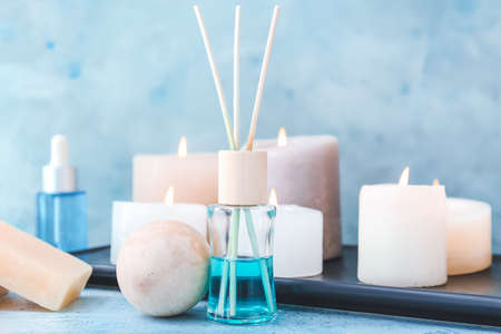 Reed air freshener and candles on color backgroundの写真素材