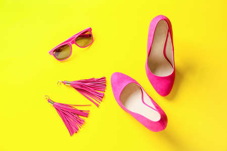 Female shoes and accessories on color background