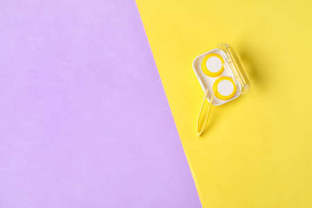 Container with contact lenses and tweezers on color backgroundの写真素材