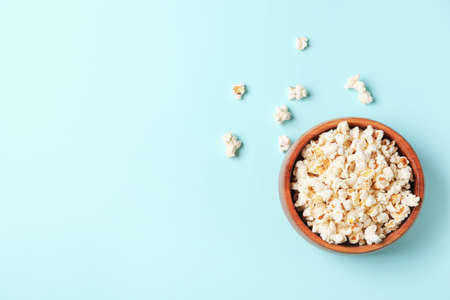 Bowl of tasty popcorn on color backgroundの写真素材
