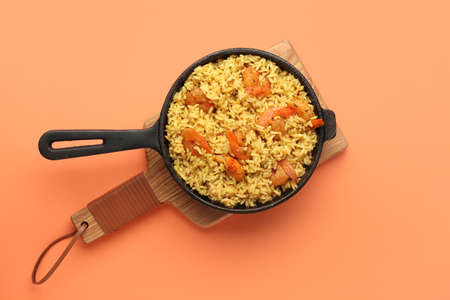 Frying pan with tasty pilaf on color backgroundの写真素材