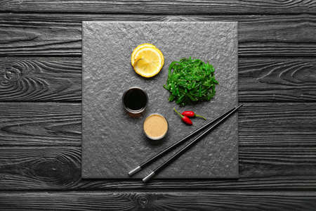 Tasty seaweed salad with sauces on table