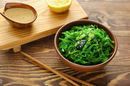 Bowl with tasty seaweed salad on tableの写真素材