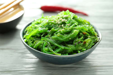 Plate with tasty seaweed salad on table