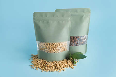 Blank coffee bags on color background