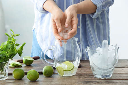 Woman making tasty mojito cocktail at tableの写真素材