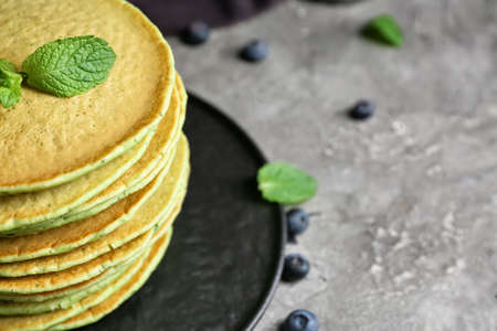 Plate with tasty green pancakes and berries on gray background, closeupの写真素材