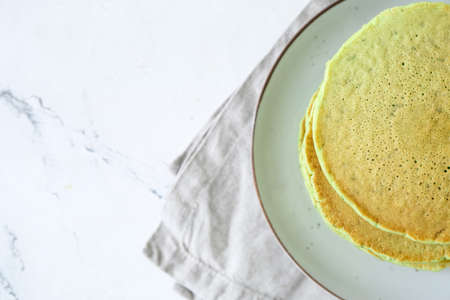 Plate with tasty green pancakes on table, closeupの写真素材