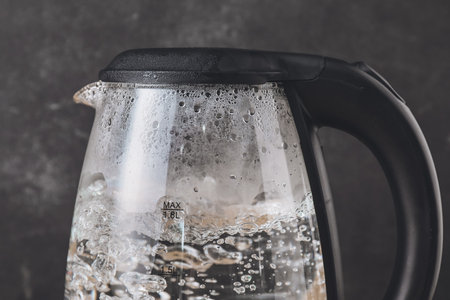 Modern electric kettle on dark backgroundの写真素材