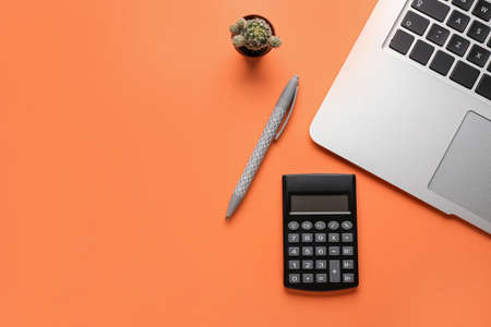 Modern calculator, pen and laptop on color backgroundの写真素材