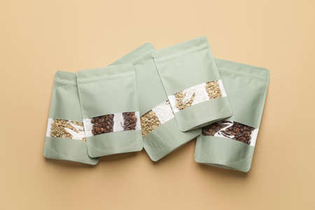 Blank coffee bags on color background