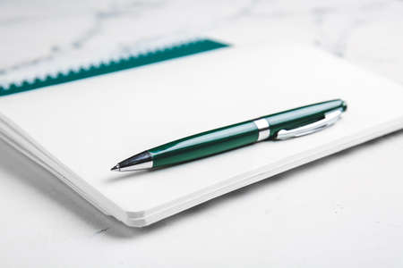 Notebook and pen on light background