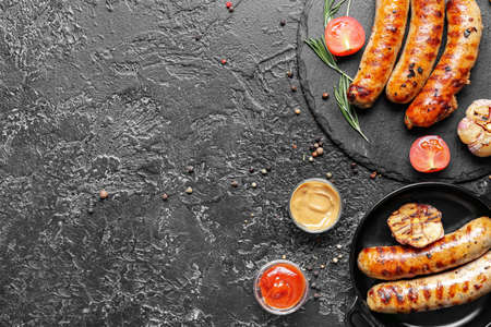 Delicious grilled sausages and vegetables on dark backgroundの写真素材