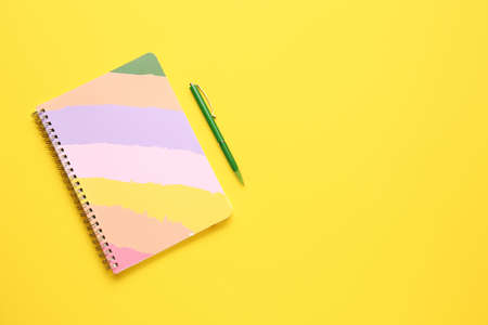 Notebook and pen on color backgroundの写真素材
