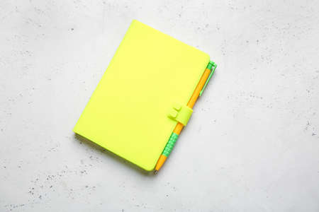 Notebook and pen on light background