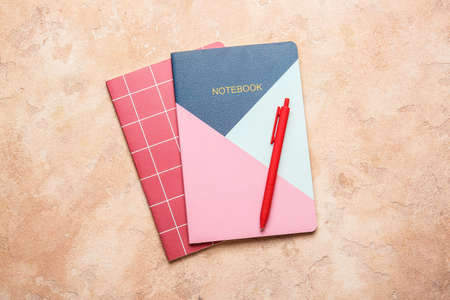 Notebooks and pen on color background