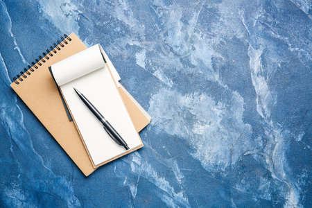 Notebooks and pen on color background