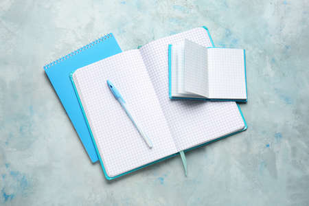 Notebooks and pen on color background
