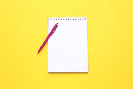 Notebook and pen on color backgroundの写真素材