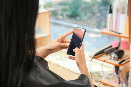 Female hairdresser working with client in salon, closeup