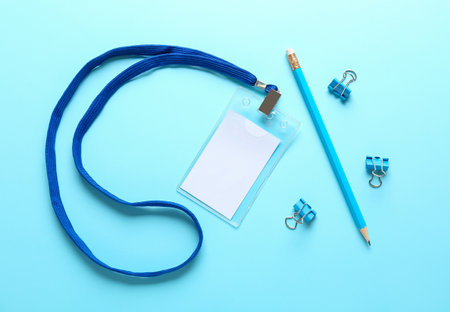 Blank badge, pencil and clips on color backgroundの写真素材