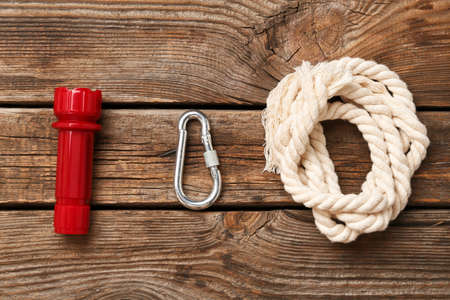 Rolled rope, lobster clasp and flashlight on wooden backgroundの写真素材