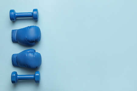Boxing gloves with dumbbells on color backgroundの写真素材
