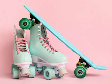 Roller skates with skateboard on color backgroundの写真素材