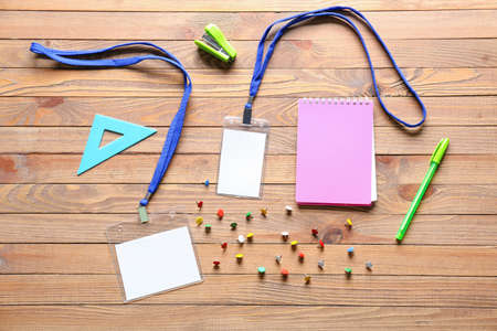 Blank badges and stationery on wooden backgroundの写真素材