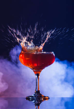 Glass of tasty coffee martini with splashes on dark backgroundの写真素材